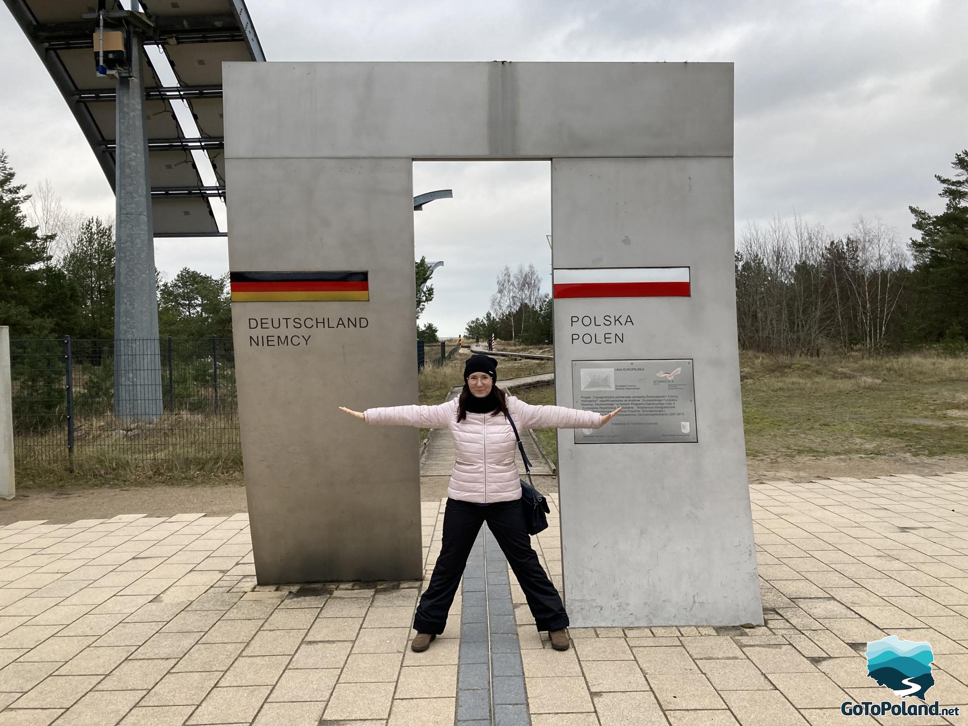 a woman is standing on the Polish-German border
