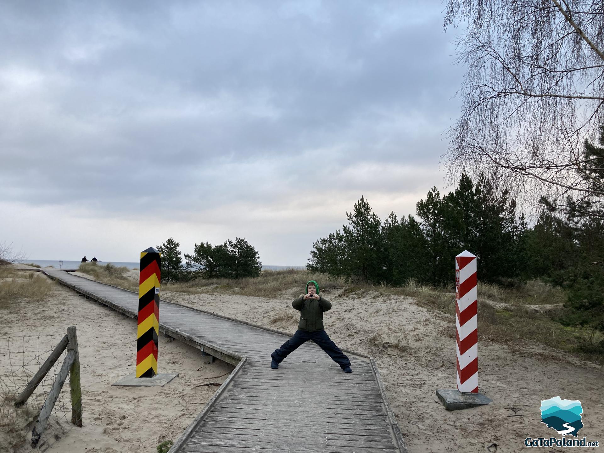 a boy is standing on the Polish-German border