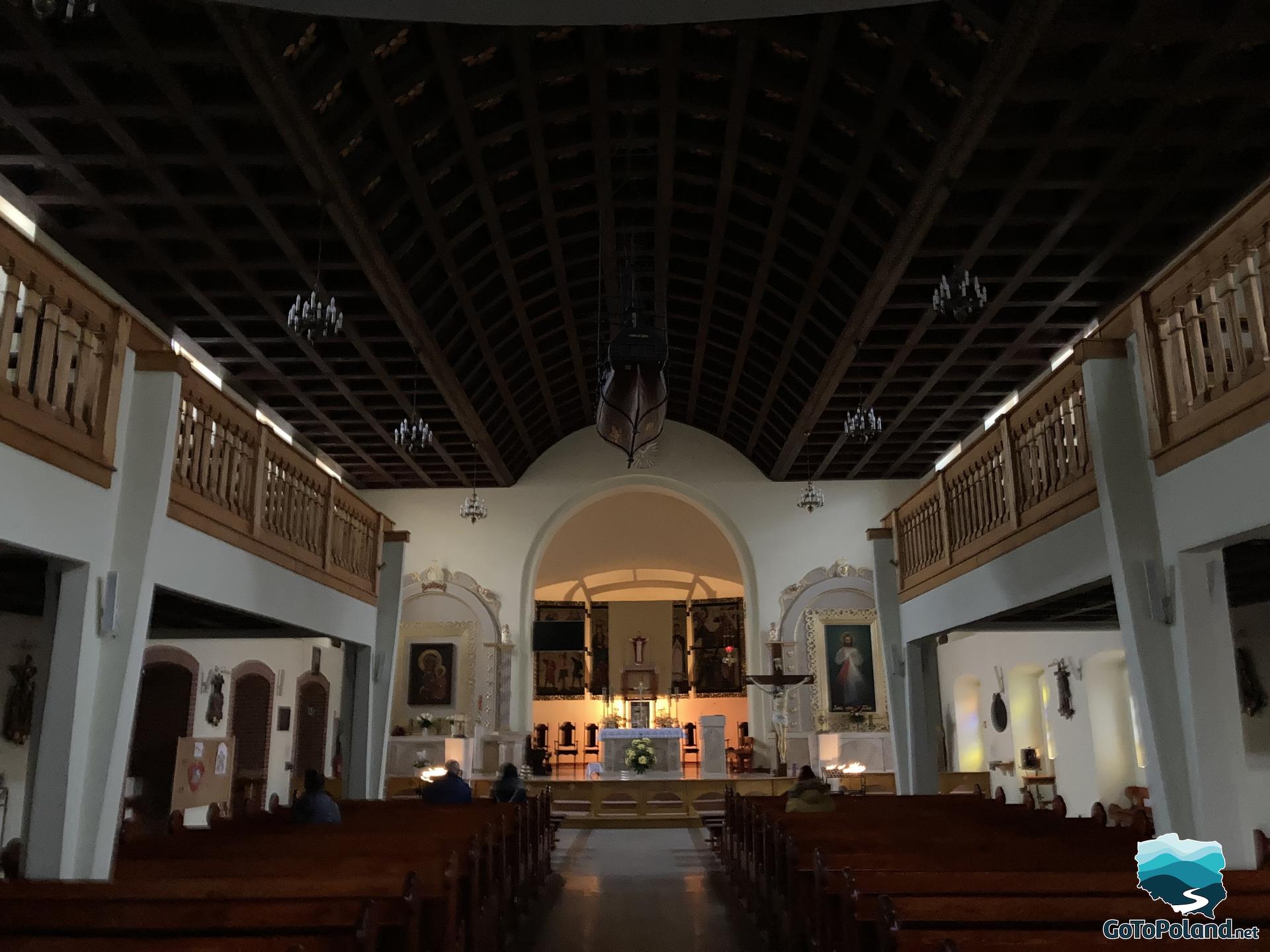the interior of a church with a wooden model of ship hanging from the ceiling 