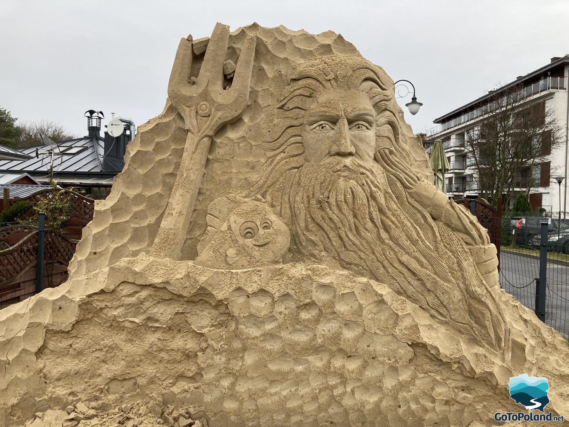 a big sand sculpture of Neptune and fish