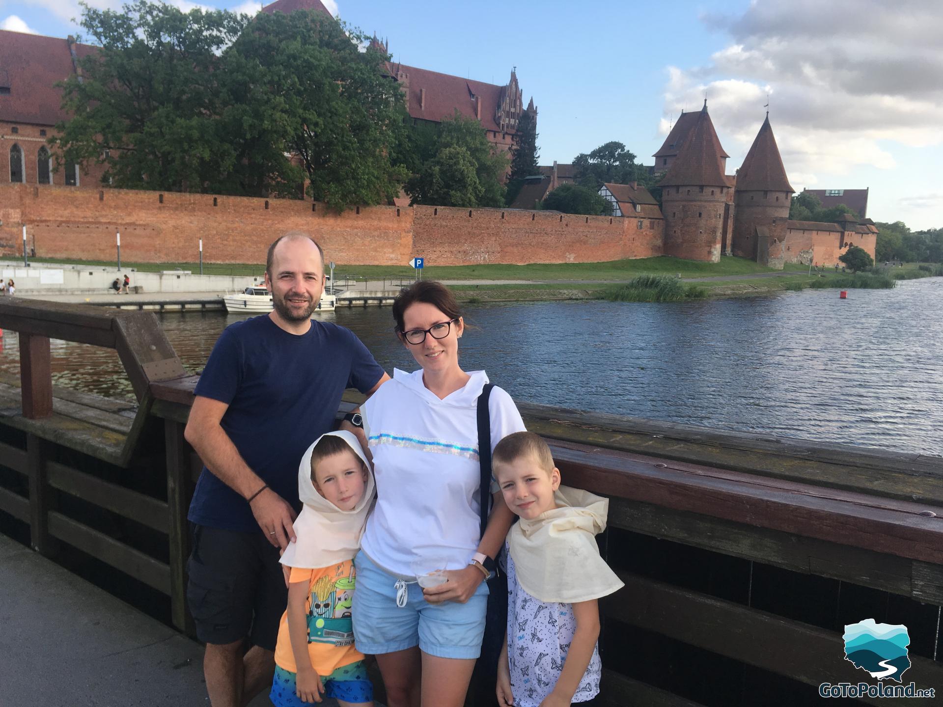 people standing on the bridge, behind them the castle