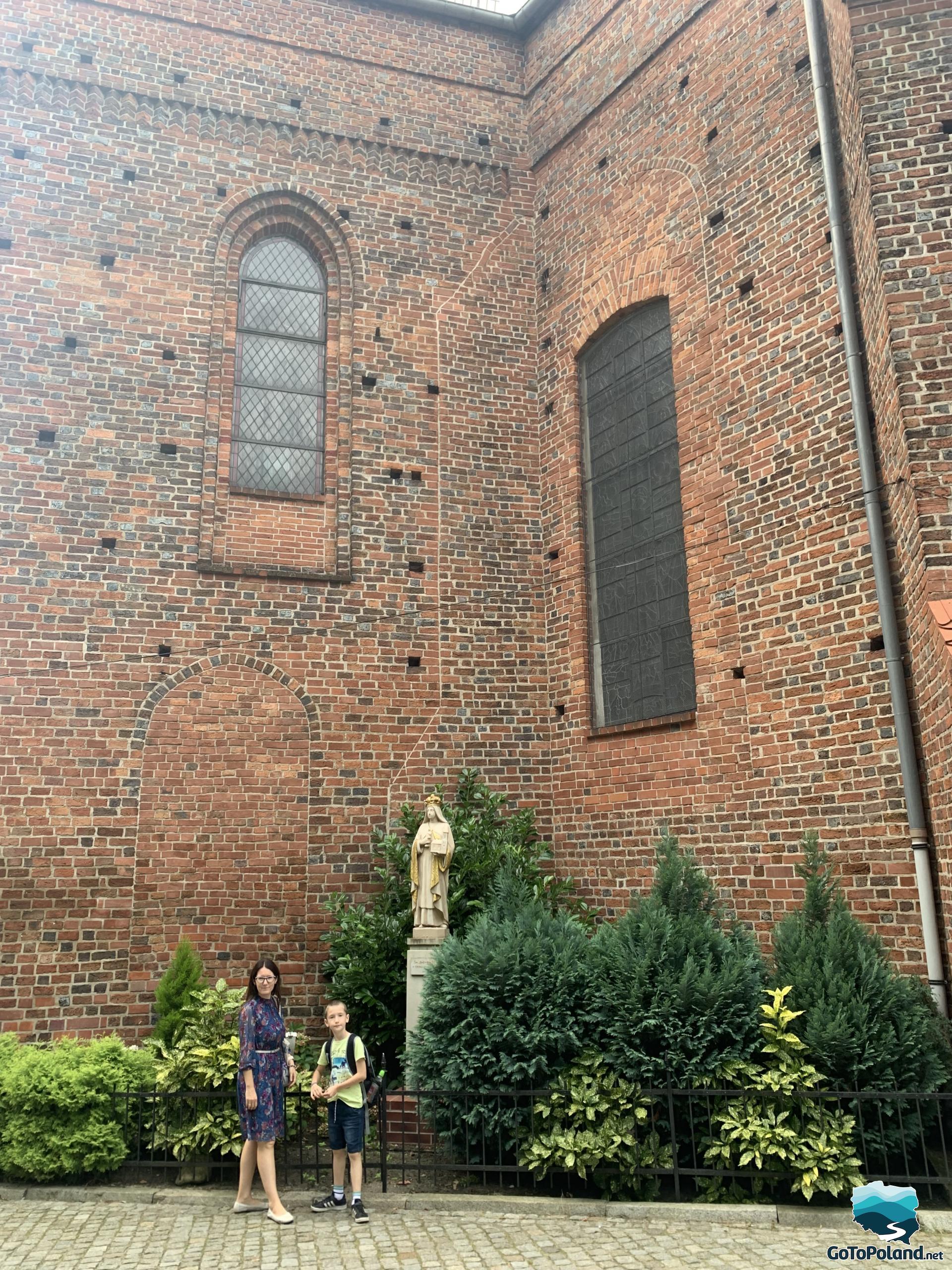 A woman and a boy in front of a brick church