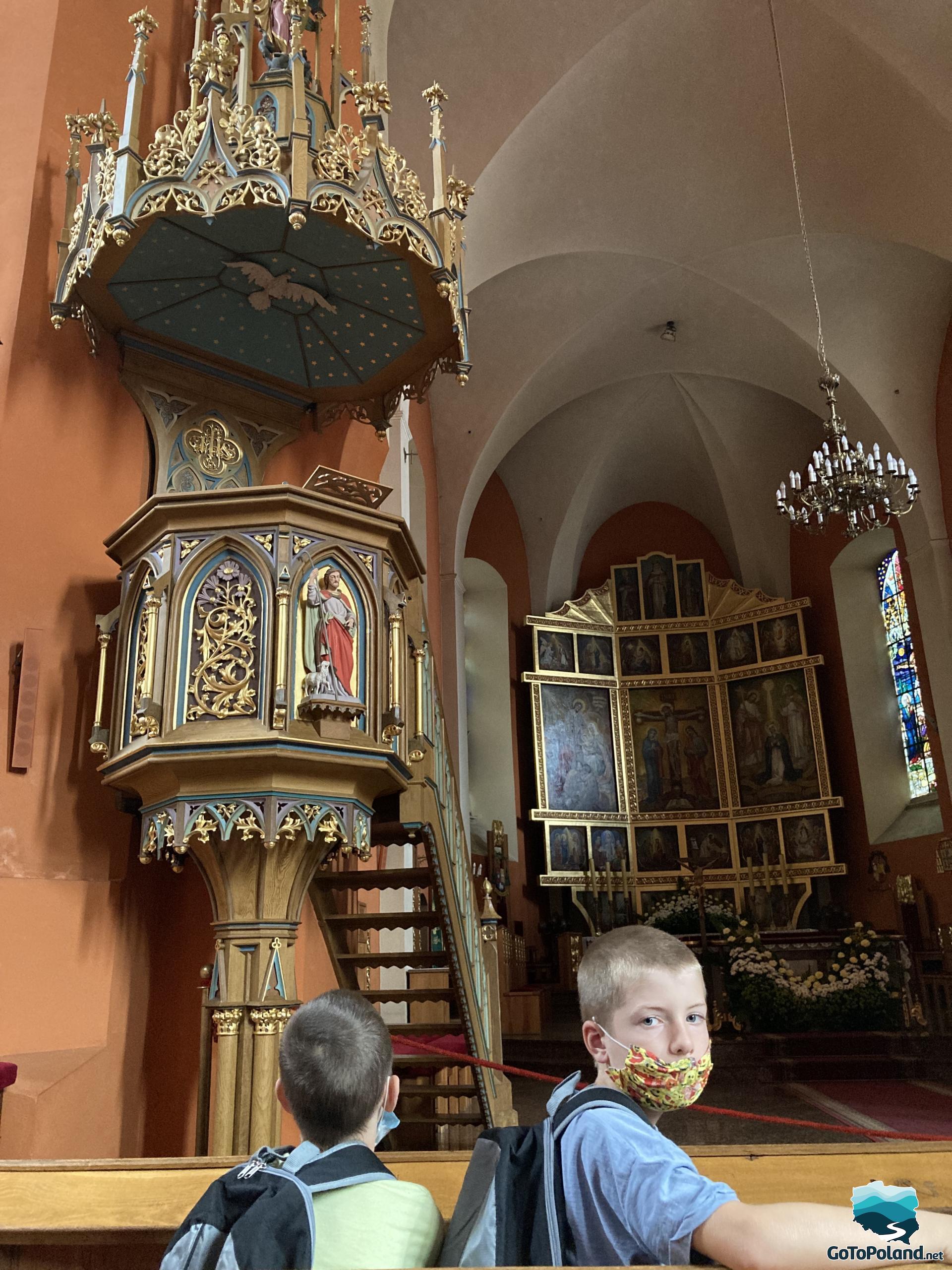A pulpit in a church and the altar in the background 