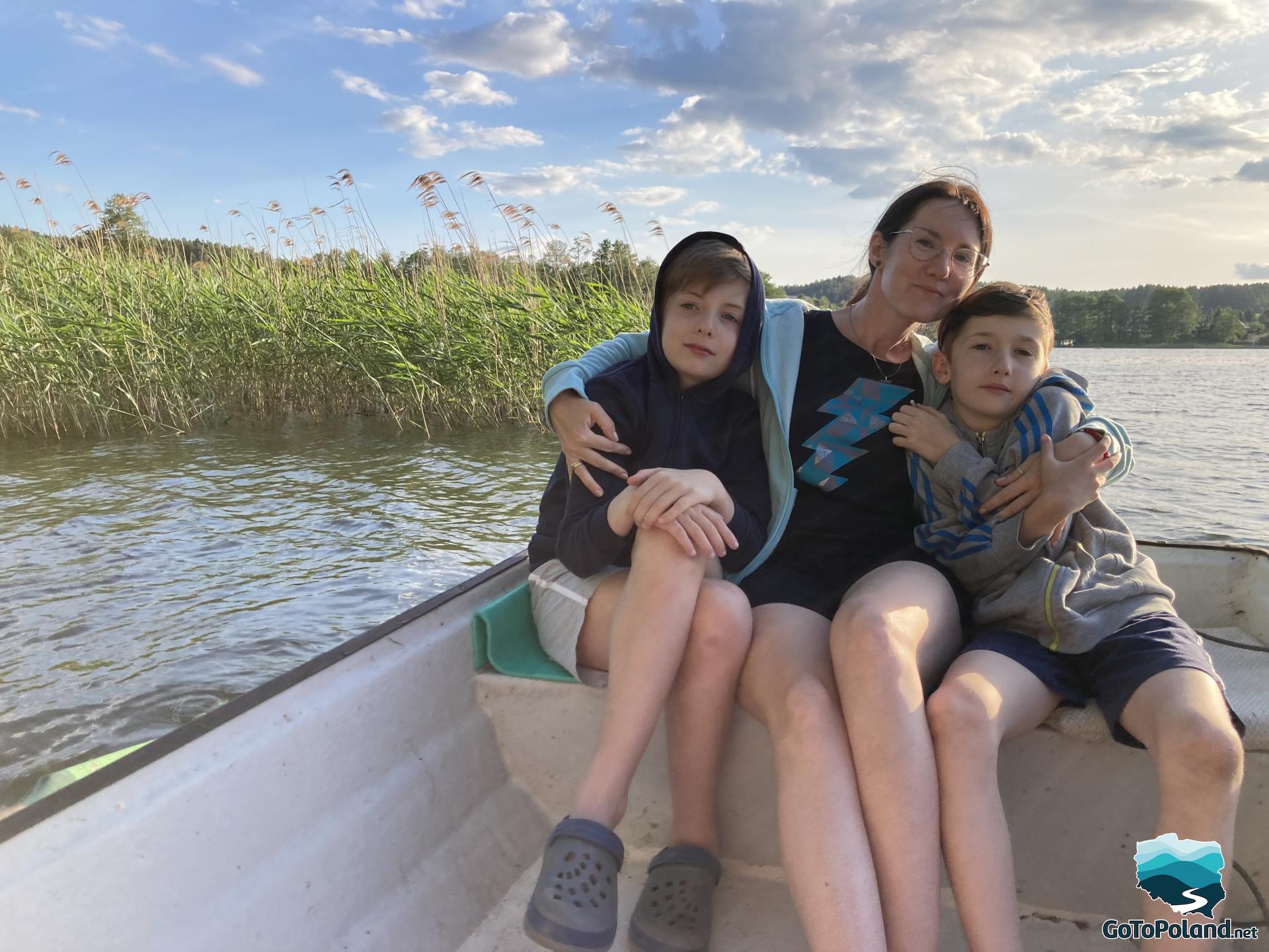 A woman and two boys on a small boat