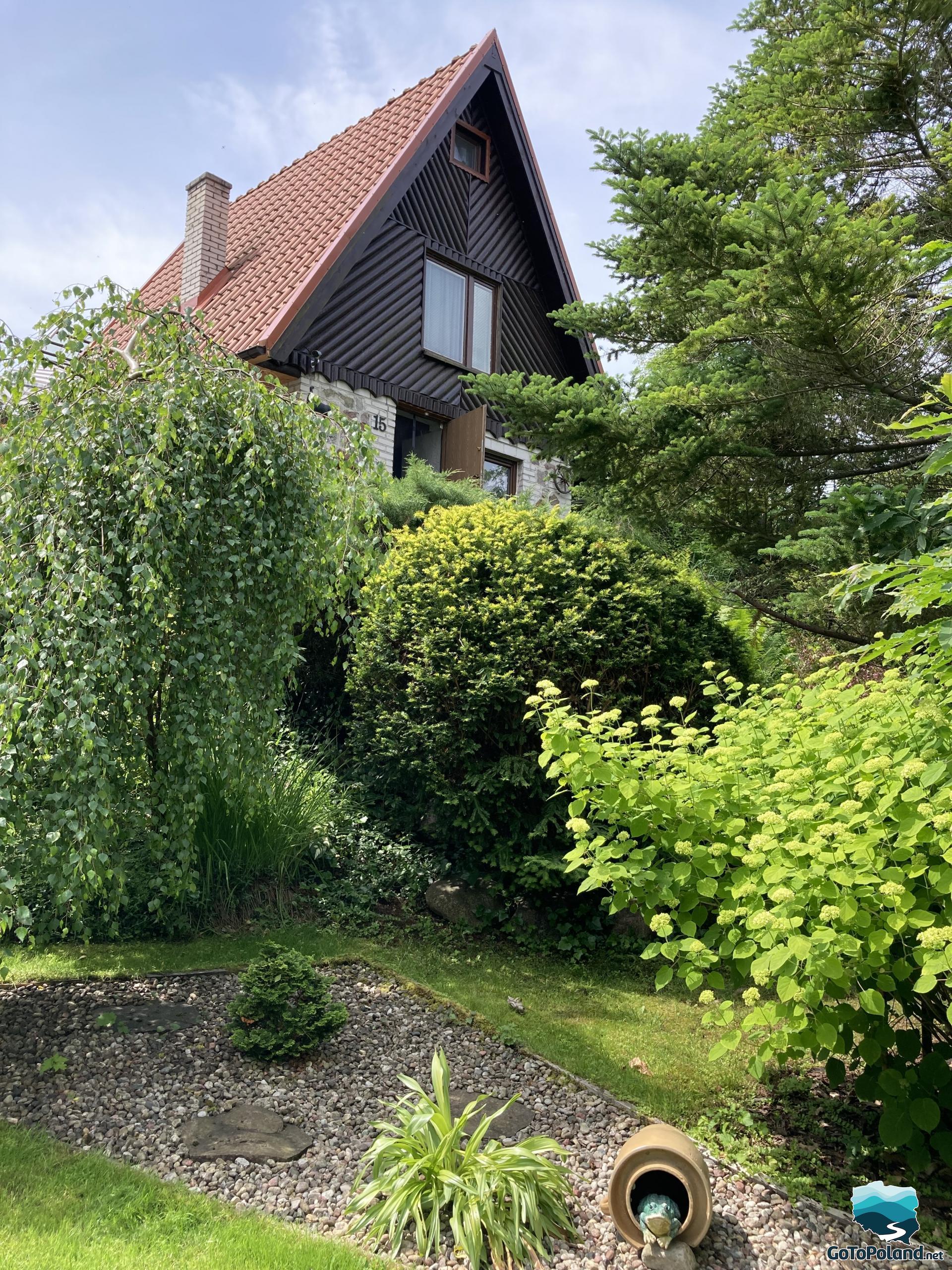 A summer house and a lot of green bushes around it