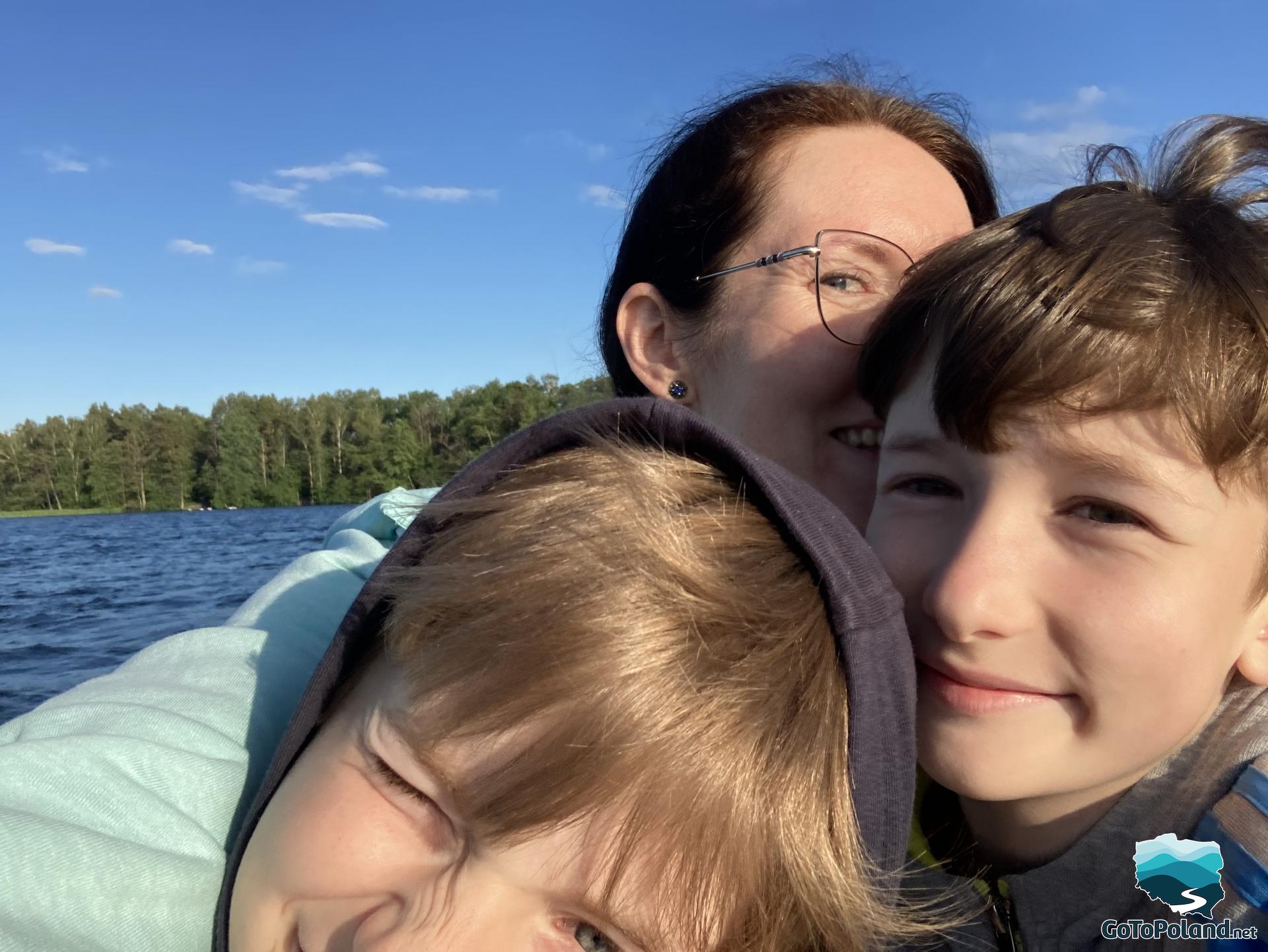 a smiling woman and two boys on a boat