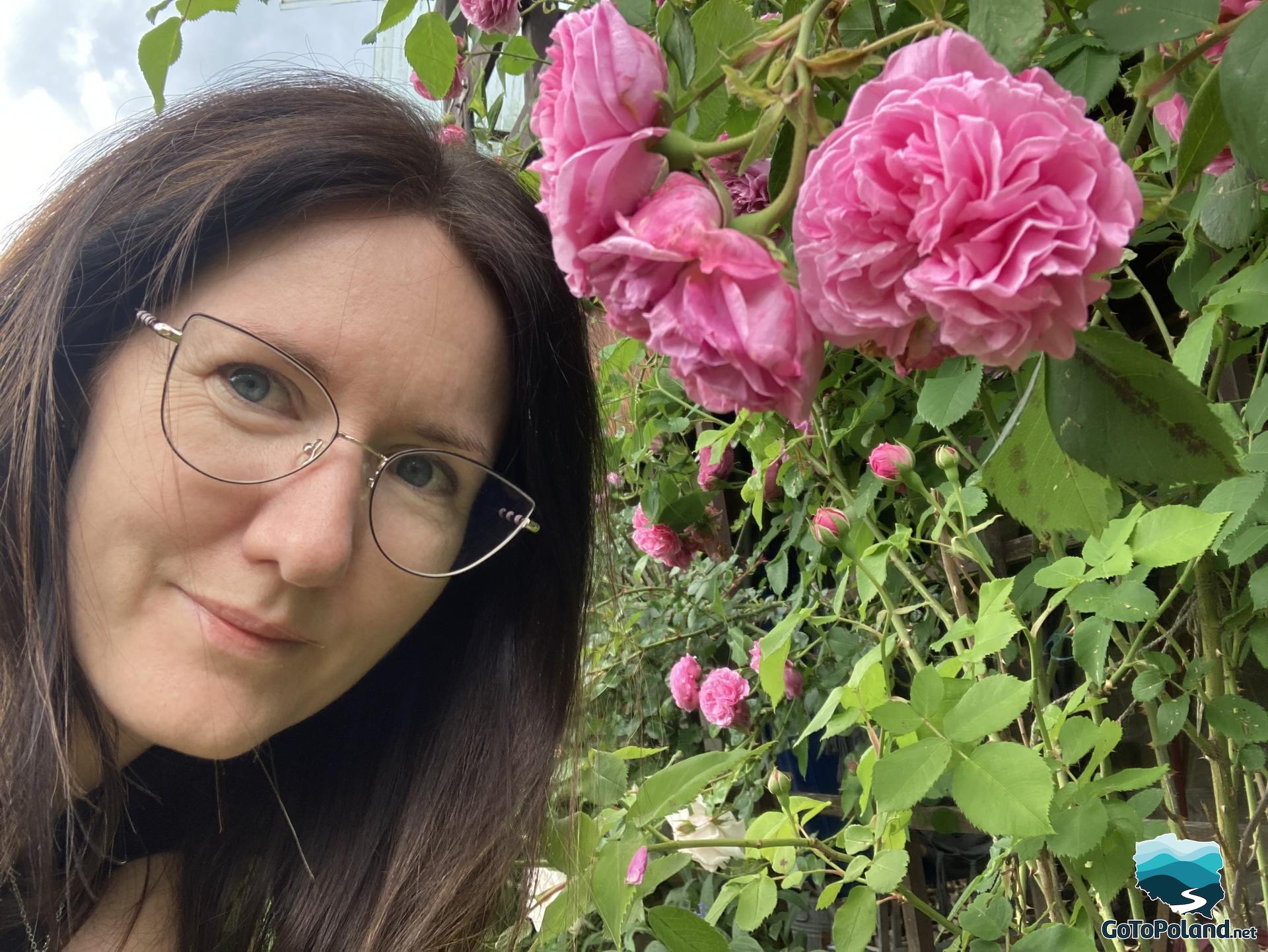 A woman smelling a pink rose