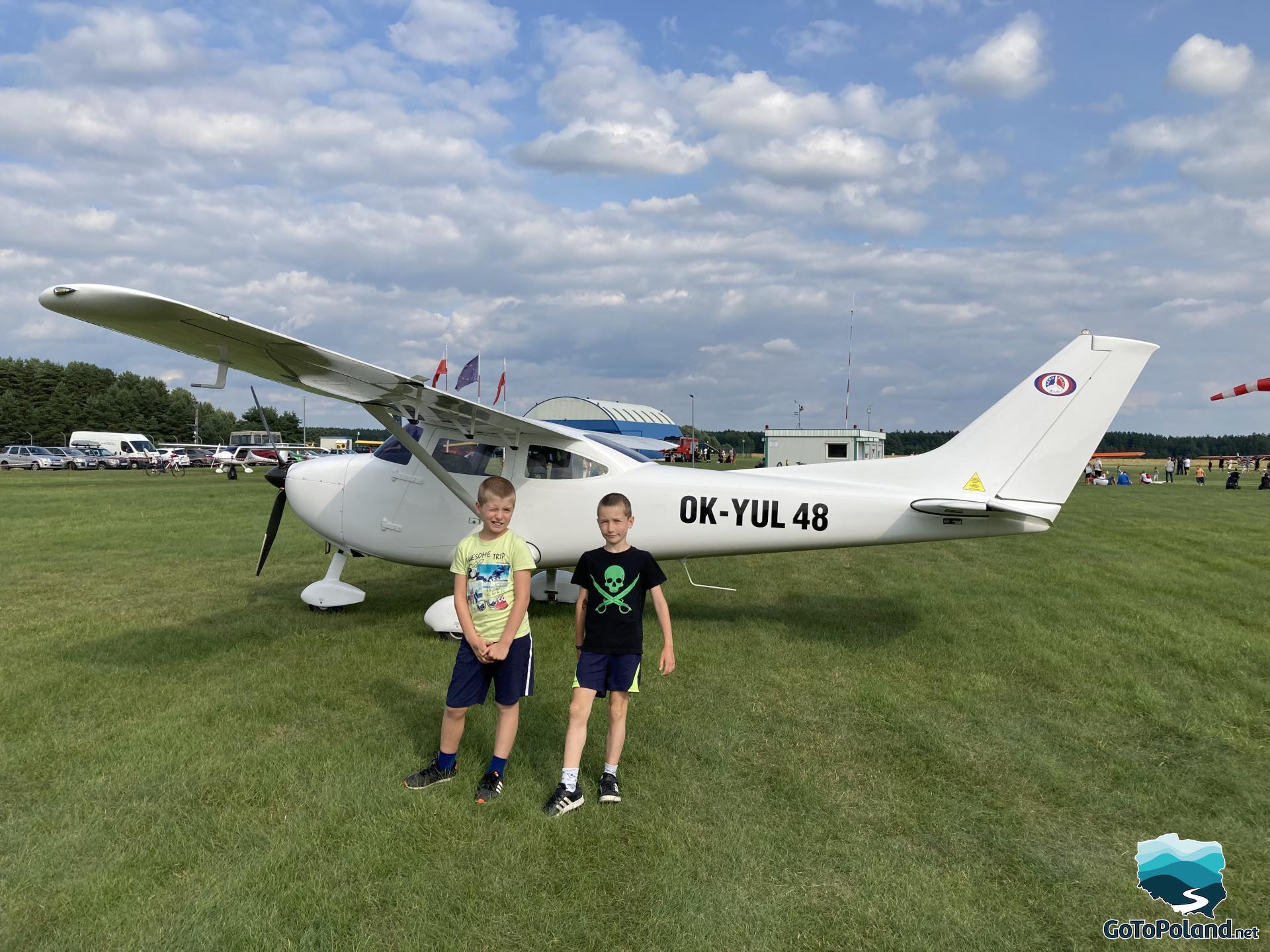 Two boys in front a small plane