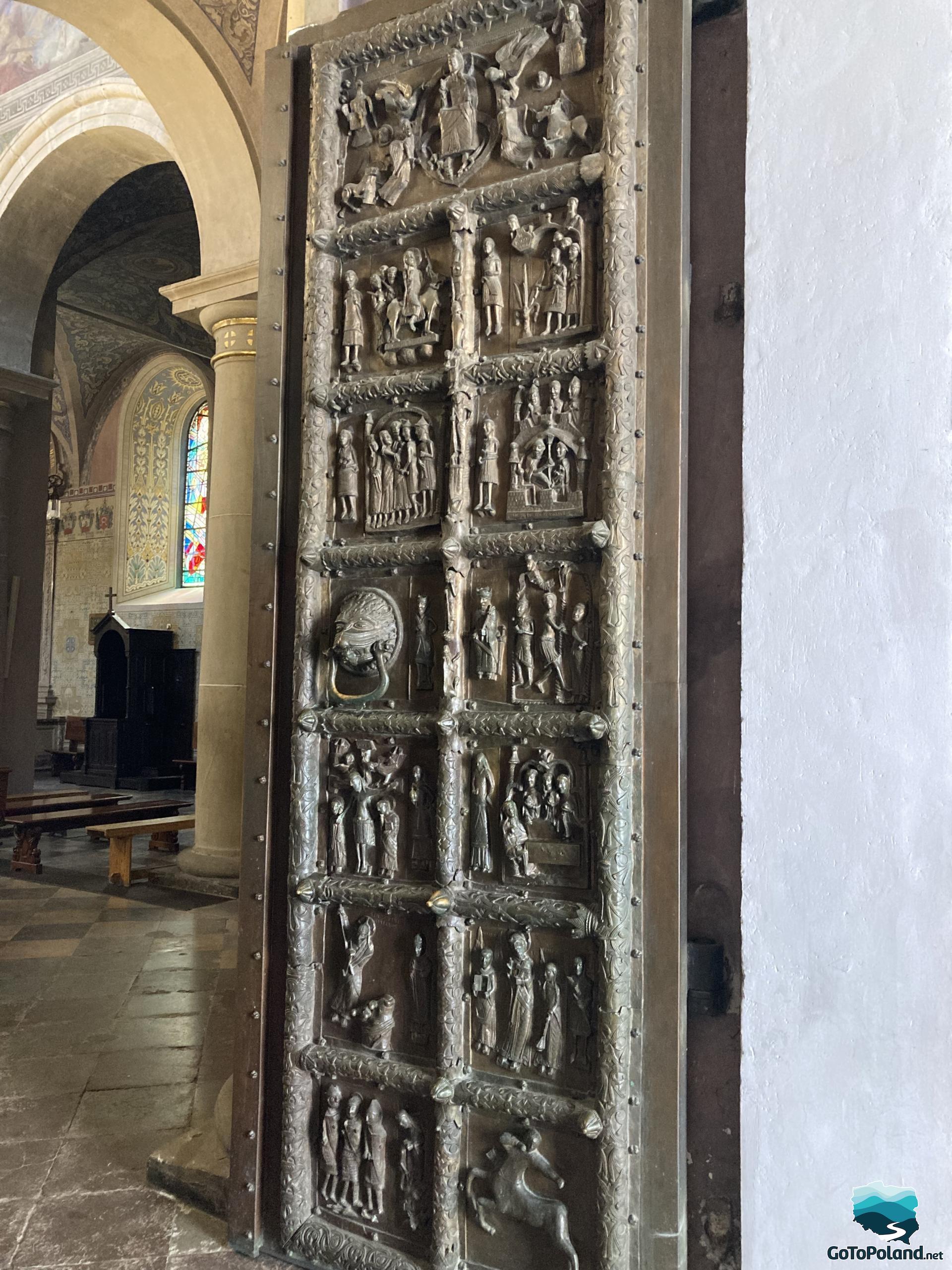 A unique door located in the entrance to the church, divided into small squares that depict various sacred scenes