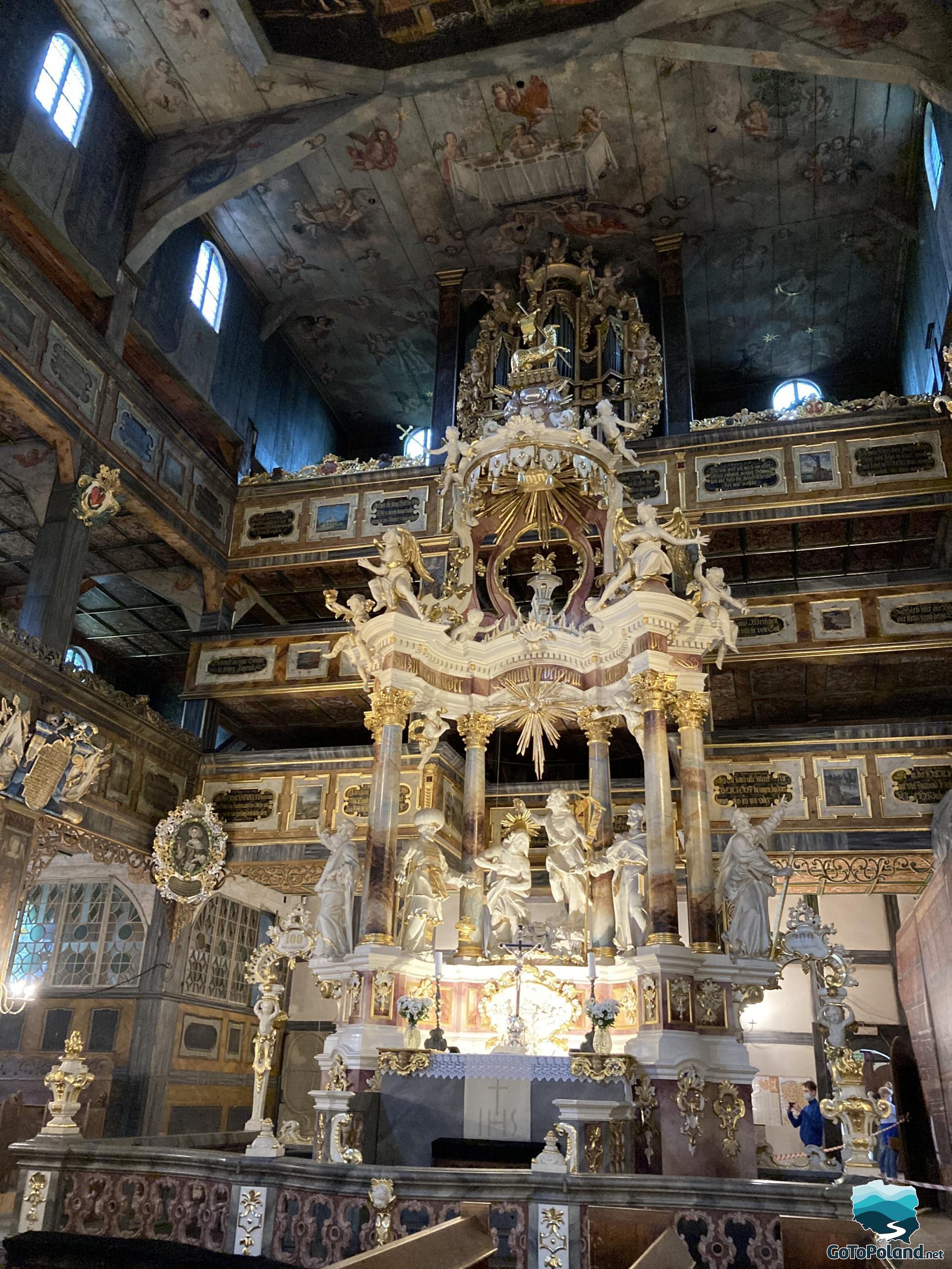 The main altar and wooden ceiling painted with saints