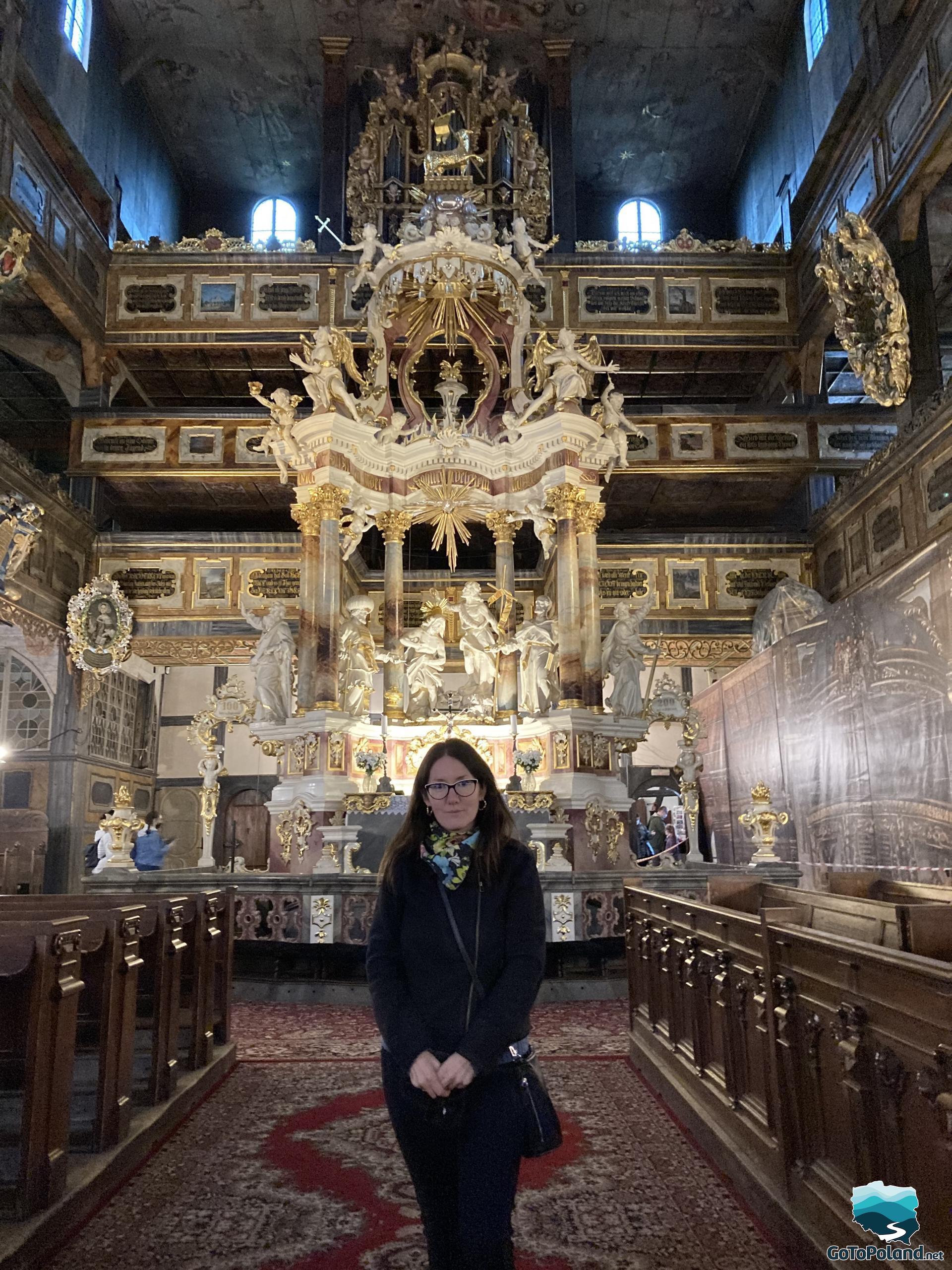 A woman is standing in front of a main altar