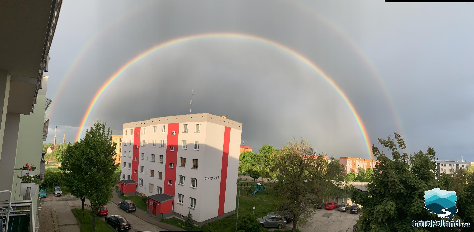 Rainbow over the block, gray sky, after the rain