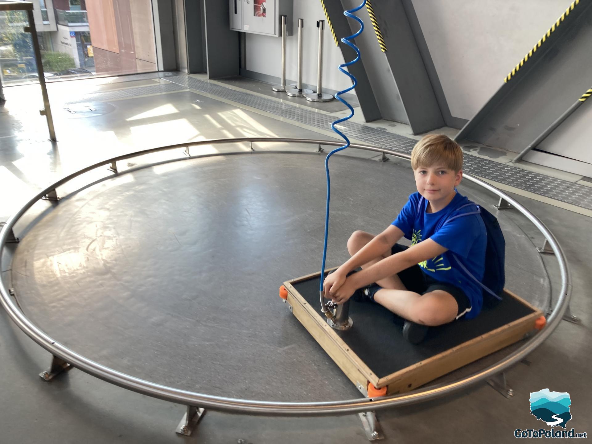 a boy is driving on a special vehicle in a science center