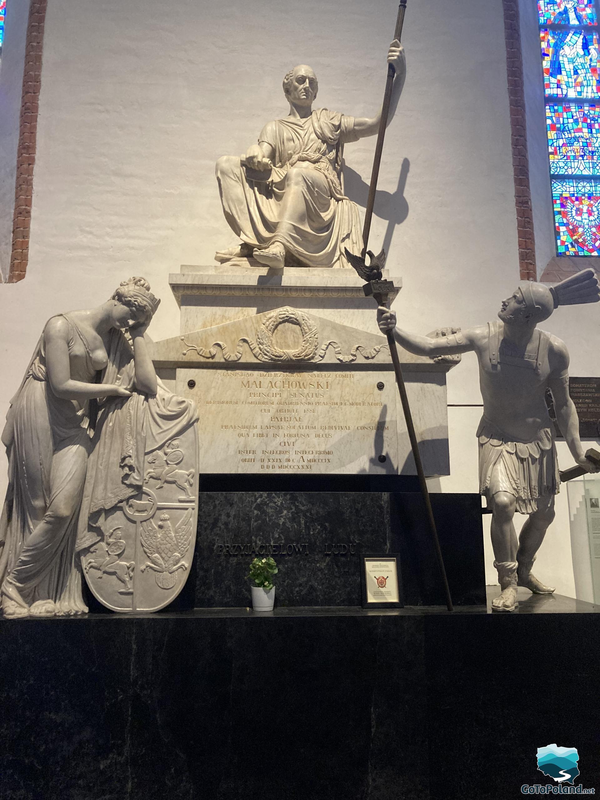 three statues in the church, one of them is on the top of the pedestal, the other rests his head on his hand, and the third holds something like a spear with a bird in it