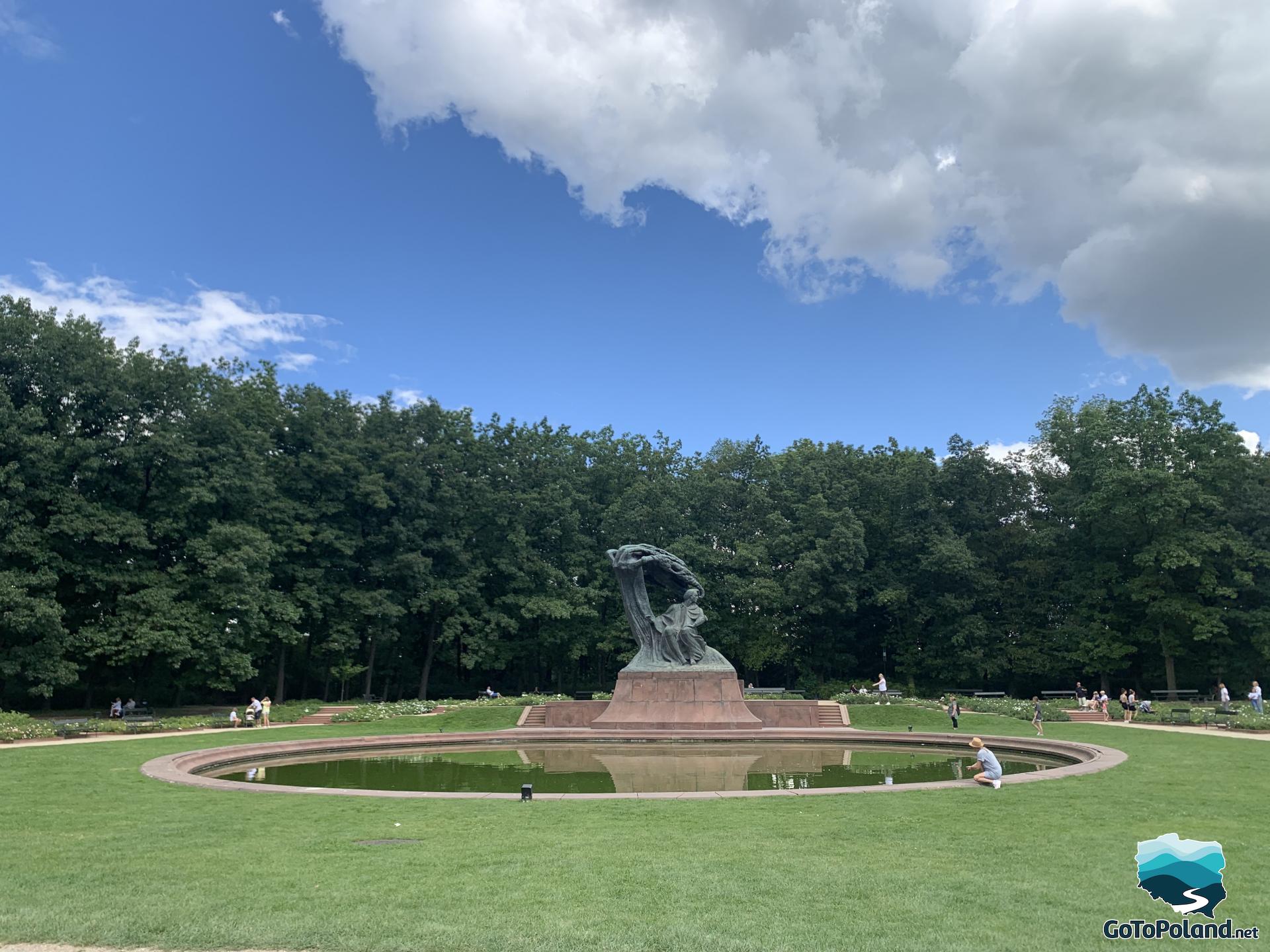 It is a large square with grass and the round pond in the center, behind the pond there is a Chopin's statue