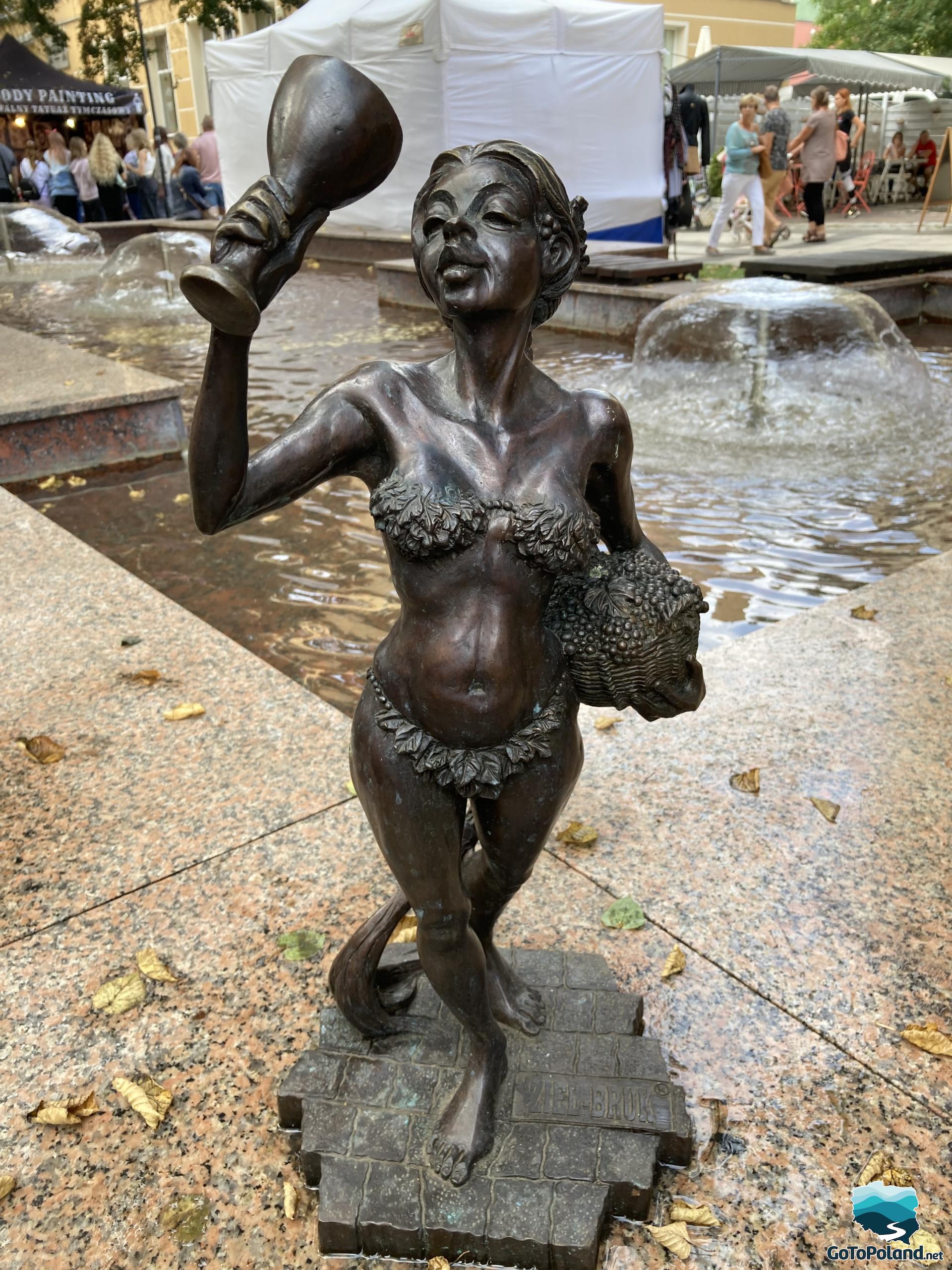A small sculpture of a woman drinking wine